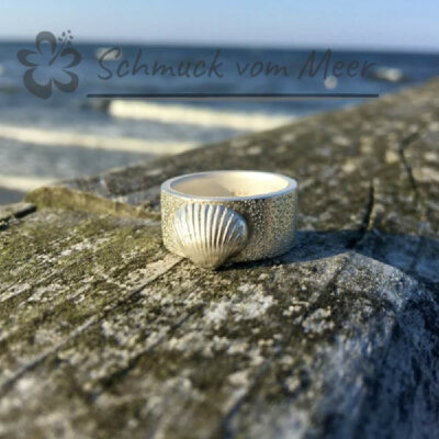 liegender Ringe mit einer kleinen Ostsseemuschel auf dem Geländer der Seebrücke in Bansin / Usedom